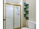 Bathroom featuring a glass door shower, tile walls, and unique corner shelving at 141 S Fraser Cir, Aurora, CO 80012