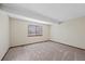 Carpeted bedroom with a large window offering ample natural light at 141 S Fraser Cir, Aurora, CO 80012