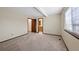 Bedroom features neutral carpeting, natural light, and an ensuite bathroom at 141 S Fraser Cir, Aurora, CO 80012