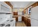 Efficient kitchen with white appliances, wood cabinets, and durable tile countertops at 141 S Fraser Cir, Aurora, CO 80012