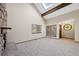 Spacious living room featuring vaulted ceilings, skylight, fireplace and new carpet at 141 S Fraser Cir, Aurora, CO 80012