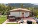 Exterior of a cozy home surrounded by trees, with a patio area perfect for outdoor gatherings at 8701 Majestic View Dr, Conifer, CO 80433