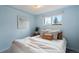 Blue bedroom featuring a comfortable bed with decorative pillows and a view out of the window at 8701 Majestic View Dr, Conifer, CO 80433