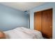 Blue bedroom featuring a comfortable bed with decorative pillows and a view out of the window at 8701 Majestic View Dr, Conifer, CO 80433