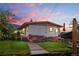 Charming single-story home with wooden deck, brick accents, and manicured lawn at dusk at 8701 Majestic View Dr, Conifer, CO 80433