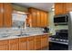 Traditional kitchen features classic oak cabinetry, stainless steel appliances, including a gas range, and white tile backsplash at 8701 Majestic View Dr, Conifer, CO 80433