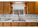 Classic kitchen sink featuring ample lighting, wooden cabinets and drawers, and a beautiful view to the backyard at 8701 Majestic View Dr, Conifer, CO 80433