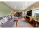 Inviting living room boasts a stone fireplace, hardwood floors, and large windows with scenic views at 8701 Majestic View Dr, Conifer, CO 80433
