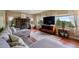 Bright and airy living room features a cozy stone fireplace and large windows offering picturesque views at 8701 Majestic View Dr, Conifer, CO 80433