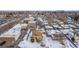 Aerial view of a house with a snowy yard and nearby buildings at 3780 Benton St, Wheat Ridge, CO 80212