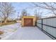 Detached brick garage with brown door in snowy backyard at 3780 Benton St, Wheat Ridge, CO 80212