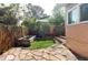 Private backyard featuring a stone patio, small lawn area, garden bed, and partial privacy fence at 1025 E Iowa Ave, Denver, CO 80210