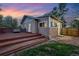Backyard with wooden deck, privacy fence, stone patio and grass at dusk at 1025 E Iowa Ave, Denver, CO 80210