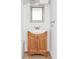 Bathroom vanity with wood cabinet, silver mirror, sink, and fixtures at 1025 E Iowa Ave, Denver, CO 80210
