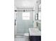 Modern bathroom features subway tile shower with glass door and pebble floor, complemented by stylish vanity at 1025 E Iowa Ave, Denver, CO 80210