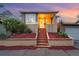 Attractive home featuring a well-kept yard, cozy porch, and an attached garage, all beautifully illuminated at 1025 E Iowa Ave, Denver, CO 80210