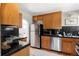 Functional kitchen featuring wood cabinets, stainless steel appliances, and granite countertops, blending style and practicality at 1025 E Iowa Ave, Denver, CO 80210