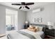 Bright main bedroom with a comfy chair, a ceiling fan, and natural light at 1025 E Iowa Ave, Denver, CO 80210