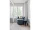 Bright sitting room featuring a comfortable chair, large windows, and a small stool for a cozy relaxation space at 1025 E Iowa Ave, Denver, CO 80210