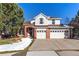 Two-story brick home with attached two-car garage and landscaped front yard at 317 Ingleton Ct, Castle Pines, CO 80108