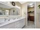 Bathroom featuring double sinks, white marble countertops, and a view into a closet space at 14116 Double Dutch Cir, Parker, CO 80134