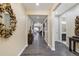 Inviting hallway with hardwood floors, ornate mirror, and decorative accents leading to various rooms at 14116 Double Dutch Cir, Parker, CO 80134