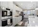 A modern kitchen featuring stainless steel appliances, white cabinetry, and marble countertops and backsplash at 14116 Double Dutch Cir, Parker, CO 80134