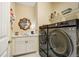 Modern laundry room with white cabinets, marble countertops, and high-end washer and dryer at 14116 Double Dutch Cir, Parker, CO 80134