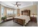 Luxurious main bedroom with tray ceiling, detailed trim, and a large bay window with seating at 14116 Double Dutch Cir, Parker, CO 80134