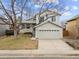 Two-story home with a well-maintained front yard, a large tree, and a two-car garage at 9057 Bermuda Run Cir, Highlands Ranch, CO 80130