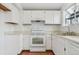 Functional kitchen with white cabinets, a double sink, and an oven at 9057 Bermuda Run Cir, Highlands Ranch, CO 80130