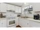 Clean kitchen featuring white cabinets, appliances, and a garden window above the sink at 9057 Bermuda Run Cir, Highlands Ranch, CO 80130