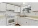 All-white kitchen featuring an oven and double sinks, with view from the window at 9057 Bermuda Run Cir, Highlands Ranch, CO 80130