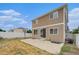Back exterior featuring a fenced yard with a patio and the back of the home with sliding glass doors at 5550 Malta St, Denver, CO 80249