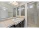 Bathroom featuring granite counters, a sink, a large mirror, and a tiled shower at 5550 Malta St, Denver, CO 80249