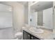 Bathroom featuring granite counters, a white sink, and a shower with a built-in shelf at 5550 Malta St, Denver, CO 80249