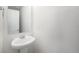 Powder room featuring a stylish pedestal sink, mirror, and clean, white walls at 5550 Malta St, Denver, CO 80249