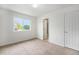 Bedroom featuring carpet, neutral walls, a large window, and an ensuite bathroom at 5550 Malta St, Denver, CO 80249