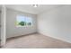 Bright bedroom featuring plush carpeting, a large window, and neutral walls at 5550 Malta St, Denver, CO 80249