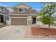 Charming two-story home featuring a well-kept lawn, attached garage, and inviting front entrance at 5550 Malta St, Denver, CO 80249