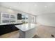 Well-lit kitchen featuring dark cabinets, island with quartz countertop, and ample natural light at 5550 Malta St, Denver, CO 80249