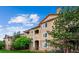 Condo complex featuring manicured landscaping, stone accents, and a private balcony on a sunny day at 8520 S Holland Ln # 102, Littleton, CO 80128