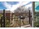 A balcony with black iron railings overlooking green space and mature trees at 5995 W Hampden Ave # 17C, Denver, CO 80227