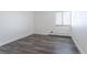 Bright bedroom featuring gray wood-look floors, white walls, and a window with blinds for natural light at 5995 W Hampden Ave # 17C, Denver, CO 80227