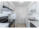 Clean kitchen with modern black appliances, ample white cabinets, and sleek countertops at 5995 W Hampden Ave # 17C, Denver, CO 80227