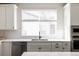 Clean kitchen with white cabinets, herringbone backsplash and large window at 10270 E 62Nd Pl, Denver, CO 80238