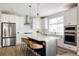 Modern kitchen with white cabinets, a large island, and stylish backsplash at 10270 E 62Nd Pl, Denver, CO 80238