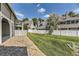 Well-maintained backyard with a lush green lawn and stone border, featuring a secure white fence at 10685 W Apishapa Pass, Littleton, CO 80127