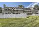 Exterior view of the building from the backyard, featuring balconies, decks, and a white picket fence at 10685 W Apishapa Pass, Littleton, CO 80127