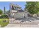 A well-maintained townhome with a two-car garage, patriotic flag, and manicured front lawn at 10685 W Apishapa Pass, Littleton, CO 80127